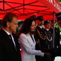 Na zdjęciu Pani Patrycja Pabich z wydziału Oświaty, Promocji, Turystyki i Sportu składająca gratulacje strażakowi. Na zdjęciu inni zaproszeni goście oraz strażacy.
