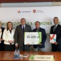 Na zdjęciu wicemarszałek Województwa Wielkopolskiego Krzysztof Grabowski, wójt Gminy Przemęt Janusz Frąckowiak, główny księgowy Alicja Bauta oraz sołtys Barchlina Jerzy Klecha wraz z radą sołecką. Wszyscy pozują na tle ścianki "Wielkopolska Odnowa Wsi". Wicemarszałek razem ze sołtysem trzymają tabliczkę, na której nadrukowane jest: "Pięknieje Wielkopolska Wieś 2024, 70 000 zł gm. Przemęt, sołectwo Barchlin. Zagospodarowanie terenu przy placu zabaw w miejscowości Barchlin".