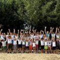 Grupowe zdjęcie dzieci wraz z opiekunami. Fotografia wykonana na plaży