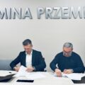 Na zdjęciu zastępca wójta oraz pan Andrzej Włodarczak - właściciel firmy podczas podpisywania umów. W tle srebrny napis "Gmina Przemęt".