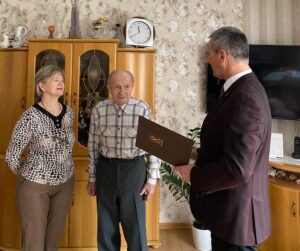 Na zdjęciu wójt gminy Przemęt odczytuje jubilatowi życzenia z listu gratulacyjnego. Na fotografii także córka Pana Józefa.