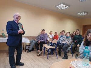 Na zdjęciu Pan Antoni Fornalski podczas wygłaszania swoich prelekcji. Na fotografii widoczni także uczniowie.