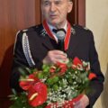 Na zdjęciu dh Zenon Klecha przemawia przez mikrofon. W ręce trzyma bukiet kwiatów.