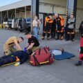 Na zdjęciu strażacy pokazują, jak prawidłowo udzielić pomocy poszkodowanemu.
