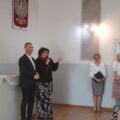 Na zdjęciu widoczny wójt gminy i dyrektor szkoły z Kluczewa, która przemawia przez mikrofon. Na zdjęciu także inne osoby.