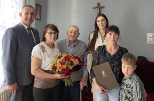 Na fotografii wójt, pracownik USC pani Natalia oraz jubilat wraz z osobami z rodziny.