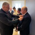 Na fotografii widoczny wicemarszałek, który przypina odznakę jednemu ze sołtysów.
