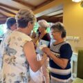 Na zdjęciu kobieta wręcza seniorce kartkę z podziękowaniem.