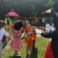 Na zdjęciu widać dzieci oraz dwie maskotki – Myszkę Miki i Myszkę Mini, które przybijają z dziećmi piątki. Na fotografii widoczna jest także nauczycielka.