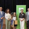 Wspólne zdjęcie, na którym są wójtowie, kierownik Placówki Terenowej KRUS, dyrektor GCKiB oraz laureatka, która pozuje z dyplomem i upominkami.