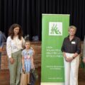 Wspólne zdjęcie, na którym są wójtowie, kierownik Placówki Terenowej KRUS, dyrektor GCKiB oraz laureatka, która pozuje z dyplomem i upominkami.