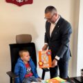 Na zdjęciu widoczny chłopiec, który siedzi na fotelu wójta. Wójt trzyma w dłoni otrzymaną od chłopca laurkę.