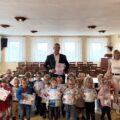 Grupowe zdjęcie dzieci i przedszkolanek wraz z wójtem i niektórymi pracownikami urzędu. Dzieci pozują z dyplomami.