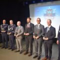 Zdjęcie przedstawia policjantów oraz przedstawicieli władz samorządowych, w tym wójta gminy Przemęt. Większość z tych osób trzyma statuetki. Wszyscy stoją na scenie.