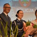 Na fotografii widoczni wójt Janusz Frąckowiak, przewodnicząca rady gminy Monika Maćkowiak oraz komendant powiatowy Policji w Wolsztynie insp. Katarzyna Sobczak-Kukawka, która trzyma bukiet kwiatów. Wszyscy stoją na scenie.