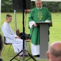 Na zdjęciu ksiądz podczas odprawiania mszy polowej. Na fotografii widoczny także ministrant.
