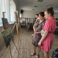 Na fotografii osoby oglądające prace pani Joanny.