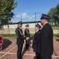 Na fotografii czwórka strażaków z OSP. Dwójka z nich podaje sobie dłoń. Na zdjęciu m.in. dh Józef Pauch oraz dh Michał Żok.