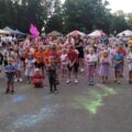 Na fotografii widoczne dzieci i młodzież podczas festiwalu kolorów.