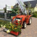 Na zdjęciu widoczny traktor ozdobiony różnymi roślinami.