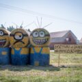 Na fotografii ozdoba dożynkowa, która przedstawia trzy minionki. Dodatkowo koło nich ustawiono szyld z napisem "Dożynki w Barchlinie mamy, na dożynki zapraszamy".
