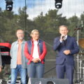 Na fotografii wójt Siedlca oraz trzy inne osoby. Wszyscy stoją na scenie, a wójt przemawia przez mikrofon.
