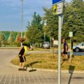 Na zdjęciu widoczna dwójka pracowników, którzy zamiatają i grabią teren za urzędem.