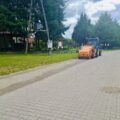Na zdjęciu z maszyną czyszczącą (z napisem MARATHON) widzimy bieżące zamiatanie jednej z ulic w gminie.