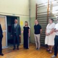 Na zdjęciu osoby biorące udział w spotkaniu rozmawiają na sali gimnastycznej.