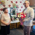 Na fotografii wójt wręcza jubilatce bukiet kwiatów.