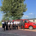 Na fotografii druhowie i druhny z OSP pozują przy czerwonym wozie.