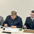 Na fotografii prezes OSP podczas podpisywania umowy. Koło niego z jednej strony siedzi skarbnik jednostki, a z drugiej strony radny Jerzy Klecha.