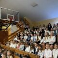 Na zdjęciu ukazani uczniowie, którzy siedzą na trybunach w sali gimnastycznej w Buczu podczas rozpoczęcia roku.