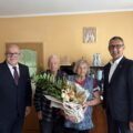 Na fotografii wójt, kierownik USC Leszek Anglart oraz pani Hildegarda, która pozuje z kwiatek w doniczce. Na zdjęciu także mąż jubilatki.