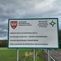 Na zdjęciu tablica. Treść znajdująca się na tablicy: "Remont drogi wojewódzkiej nr 316 na odcinku Kaszczor - granica województwa. Zadanie realizowane i finansowane przez samorząd województwa wielkopolskiego". Na tablicy umieszczono też logo: Samorządu Województwa Wielkopolskiego i logo Wielkopolski Zarząd Dróg Wojewódzkich w Poznaniu.