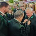 Fotografii przedstawia moment przypinania odznak zasłużonym członkom.