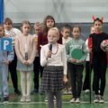 Na zdjęciu widoczna dziewczynka podczas występu artystycznego. W tle inni uczniowie.