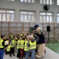 Na zdjęciu widoczna policyjna maskotka "Pyrek", która wita się się z uczniami.