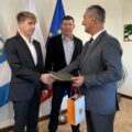Na fotografii widoczny wójt, który składa gratulacje Alanowi. W tle ojciec Alana.