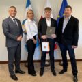 Na fotografii wójt i Alan Sadowski wraz z rodzicami. Alan pozuje z czekiem i upominkiem.