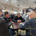Na zdjęciu widoczni uczestnicy turnieju siedzący przy stołach.