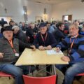 Na zdjęciu widoczni uczestnicy turnieju siedzący przy stołach.