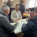 Na zdjęciu widoczni uczestnicy turnieju siedzący przy stole. Wśród grających wójt gminy Przemęt.