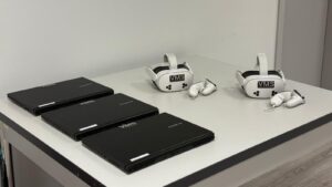 Na zdjęciu zestaw treningowy w technologii Virtual Reality (VR) oraz trzy laptopy.