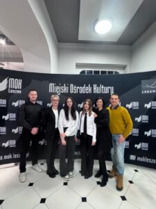 Na zdjęciu dwie uczennice wraz ze swoimi bliskimi. Wszyscy pozują na tle ścianki z napisem "Miejski Ośrodek Kultury".