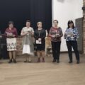 Na zdjęciu widoczne kobiety z UTW, które śpiewają oraz jeden mężczyzna, który przygrywa im na akordeonie.
