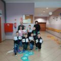 Grupowe zdjęcie dzieci po konkursie z tabliczki mnożenia. Dzieci pozują z dyplomami.