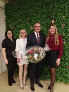Na fotografii wójt Janusz Frąckowiak wraz z członkiniami fundacji. Wójt pozuje z wieńcem świątecznym.