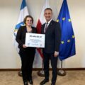 Na fotografii wójt wraz z radną Bernadetą Golińską pozują z czekiem dla Biskupic. W tle widoczne są flagi: Polski, Unii Europejskiej oraz z herbem gminy Przemęt.