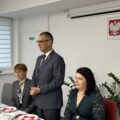Na fotografii widoczny wójt, który przemawia podczas spotkania. Koło niego znajdują się przewodnicząca rady oraz dyrektor GOPS.